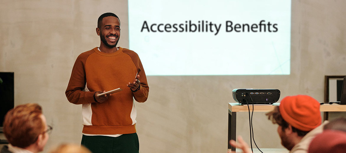 man standing presenting to coworkers about digital accessibility