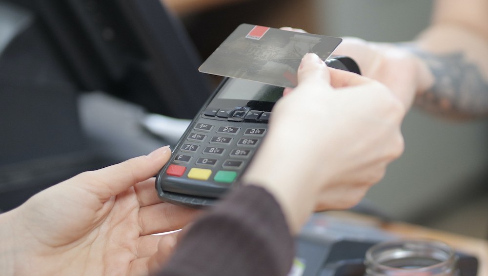person processing a credit card with focus on hands